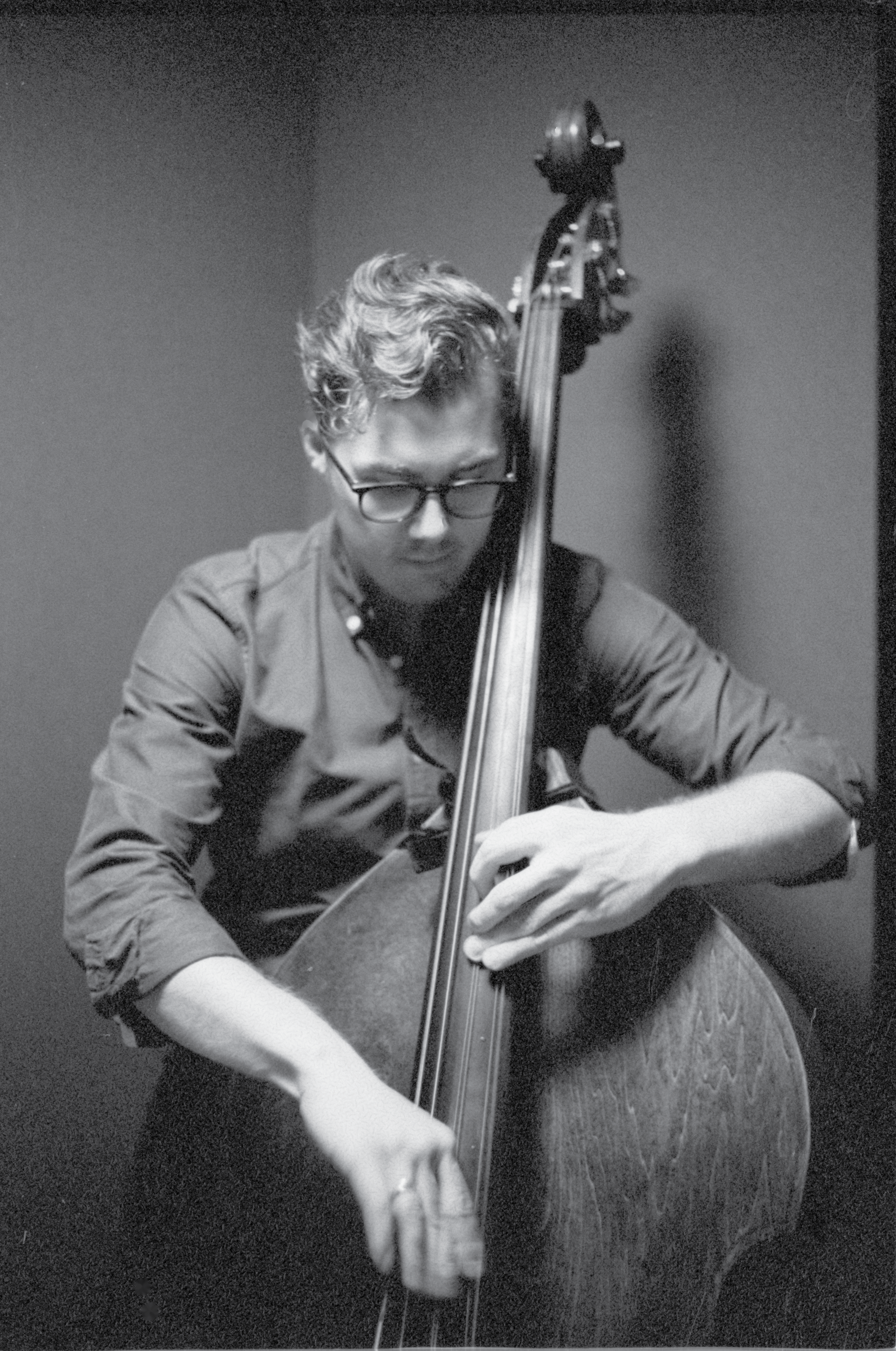 Black and white image of Alexander Svensen looking down as he plays the bass.